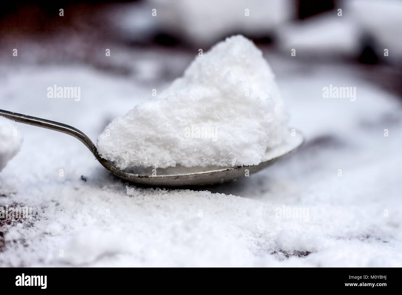 Salz, Natriumchlorid in eine hölzerne Schaufel auf Holzboden. Stockfoto
