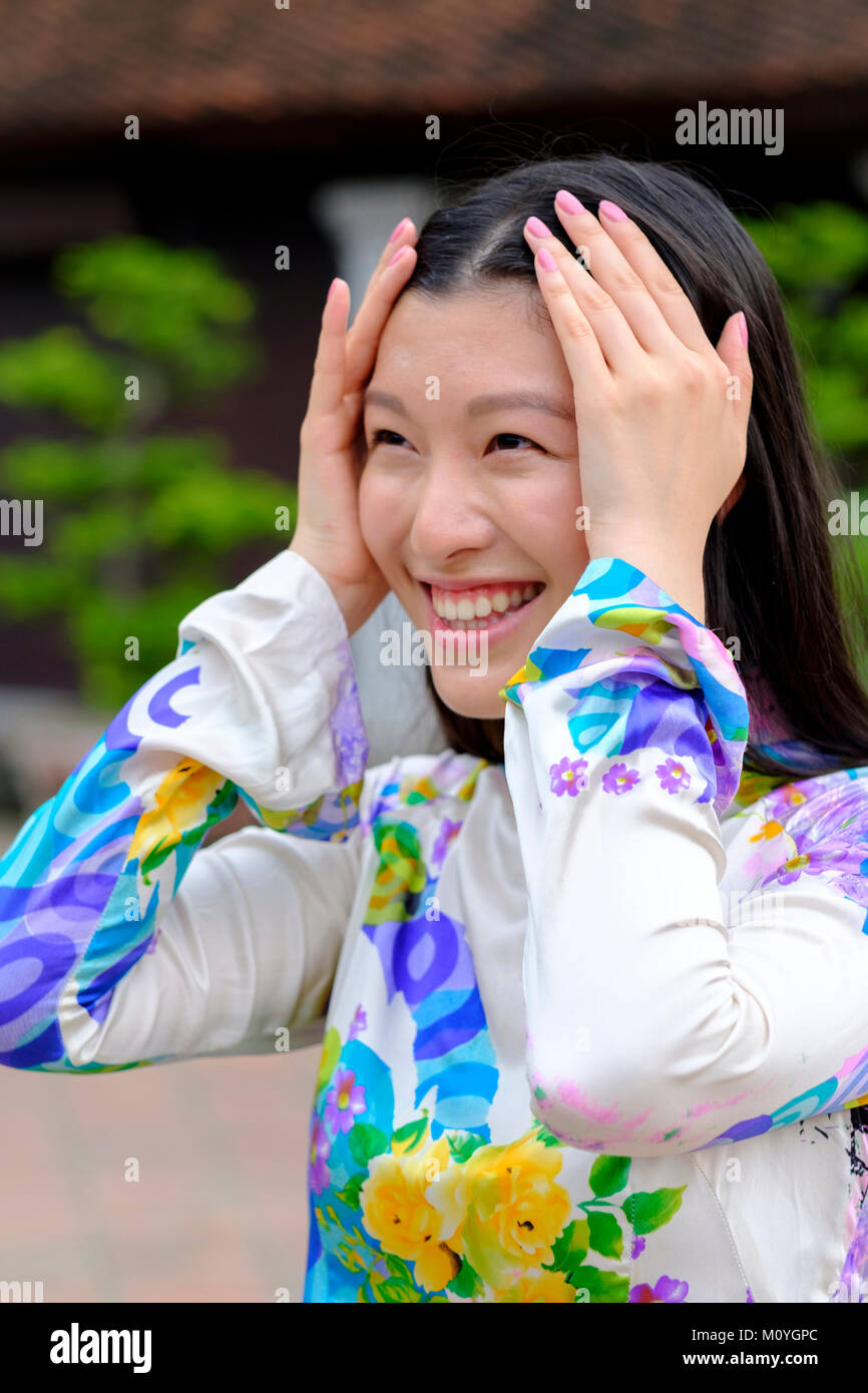 Vietnamesische Frau lächelnd und das Tragen eines traditionellen Ao Dai Kleid Stockfoto