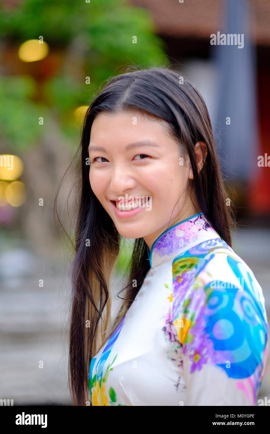 Vietnamesische Frau lächelnd und das Tragen eines traditionellen Ao Dai Kleid Stockfoto