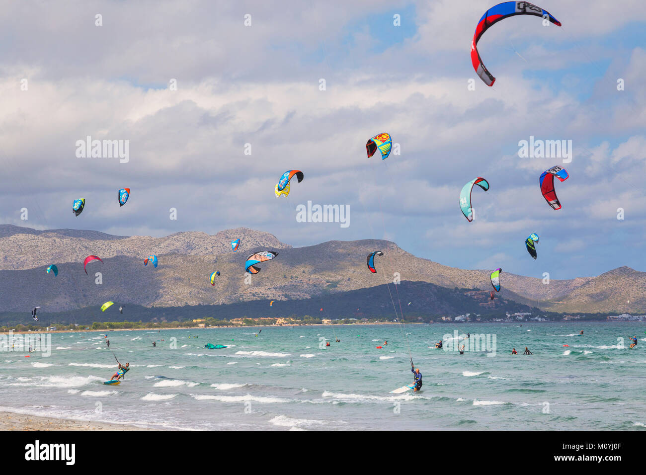 Kitesurfen auf Wellen im Meer, Strand von Alcudia, Mallorca, Balearen, Spanien Stockfoto