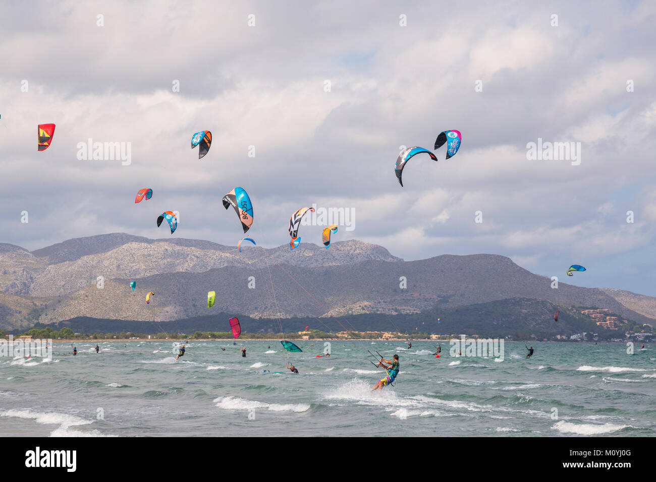 Kitesurfen auf Wellen im Meer, Strand von Alcudia, Mallorca, Balearen, Spanien Stockfoto