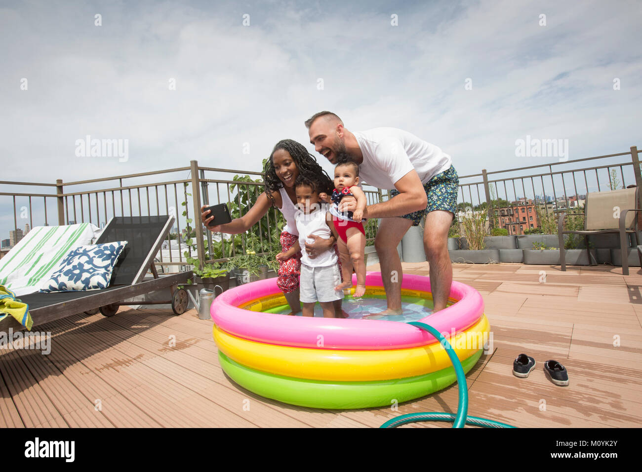 Für Eltern mit Kindern in selfie aufblasbare Pool posiert Stockfoto