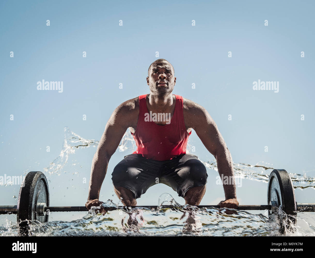 Wasser spritzen auf schwarzer Mann Vorbereitung für die Aufhebung barbell Stockfoto