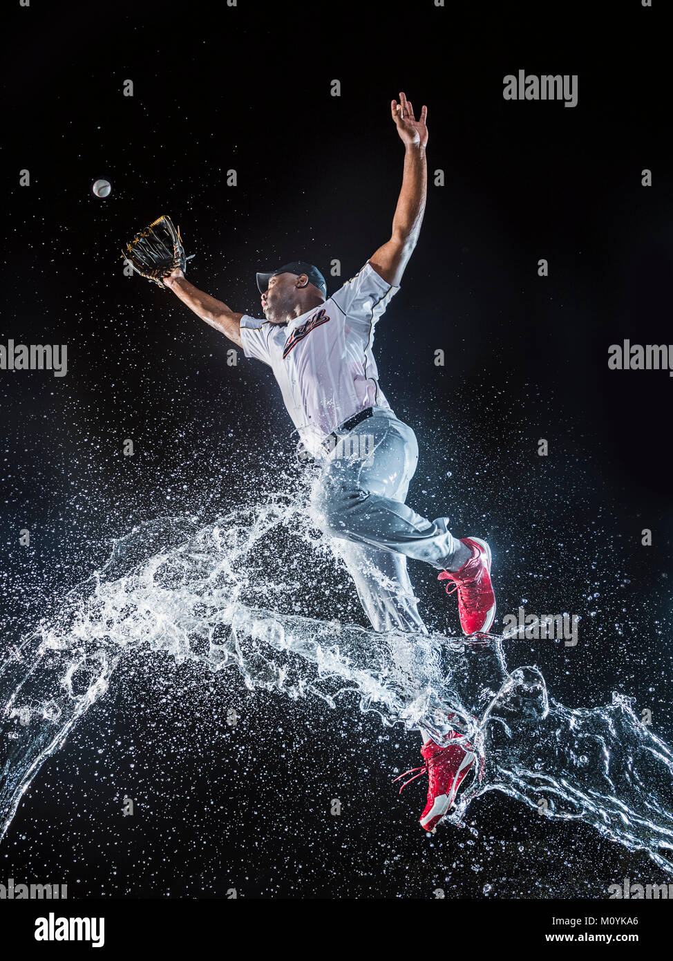 Spritzwasser springen schwarzen Baseballspieler Stockfoto