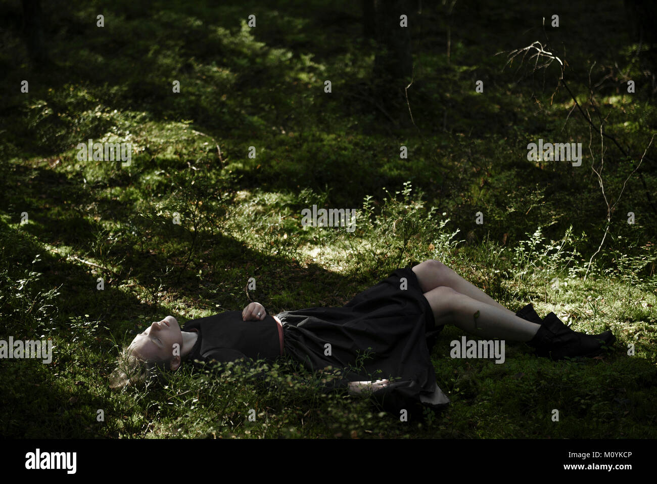 Schatten auf kaukasische Frau Festlegung im Gras Stockfoto
