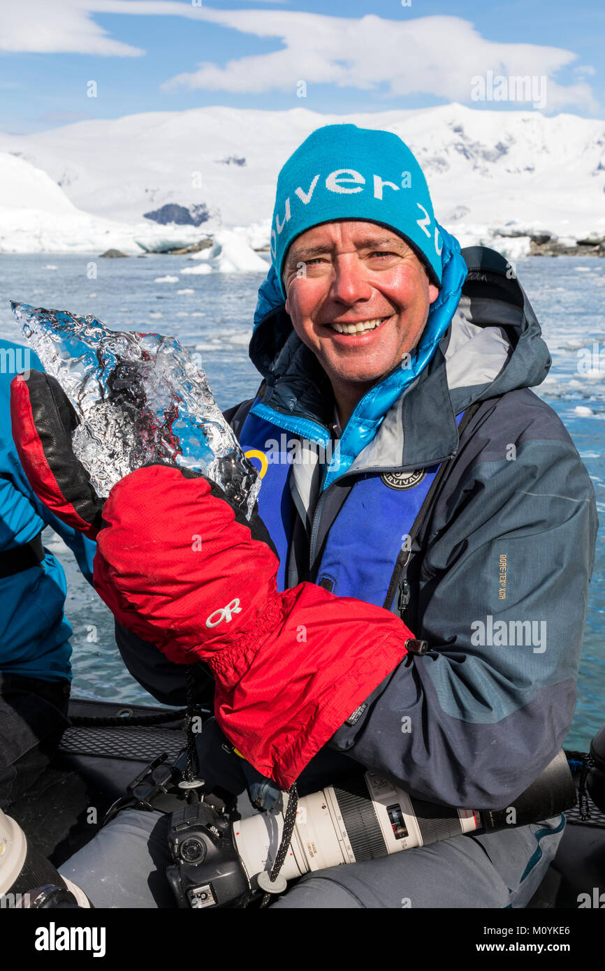Expedition Mitglied in Zodiac Boot hält kristallklare Gletschereis; Zodiacs shuttle alpinen Bergsteigen Skifahrer in die Antarktis aus dem Passagierschiff Stockfoto