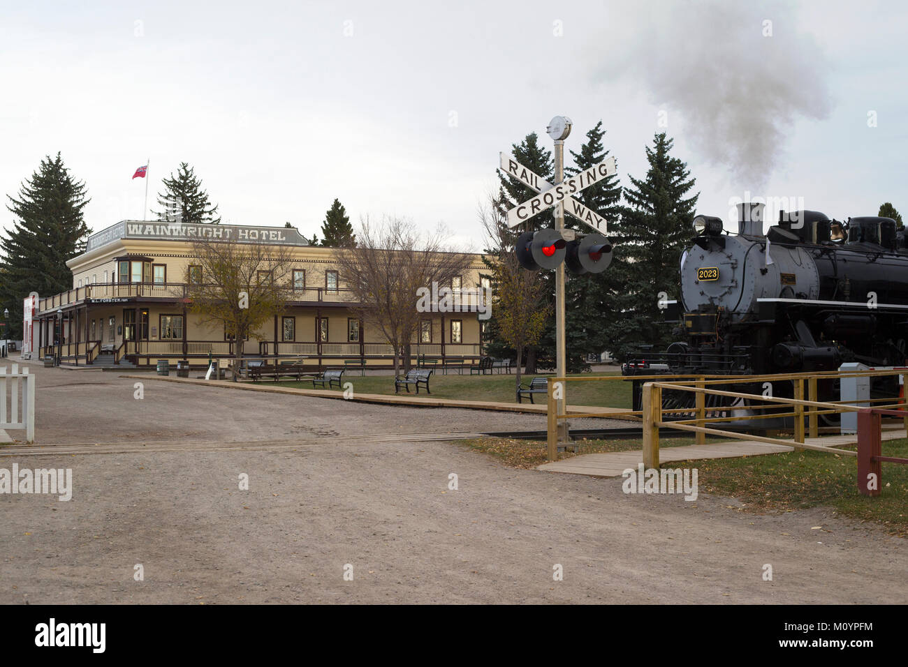 Historischer Dampfzug nähert sich Bahnübergang im Heritage Park Historical Village, Calgary, Alberta, Kanada Stockfoto