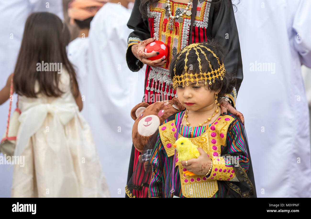 Nizwa, Oman - 26. Juni 2017: kleines Mädchen in traditionellen Outfit, mit ihrer Mutter zu einem Spielzeug Markt an einem Tag des Eid al Fitr Stockfoto