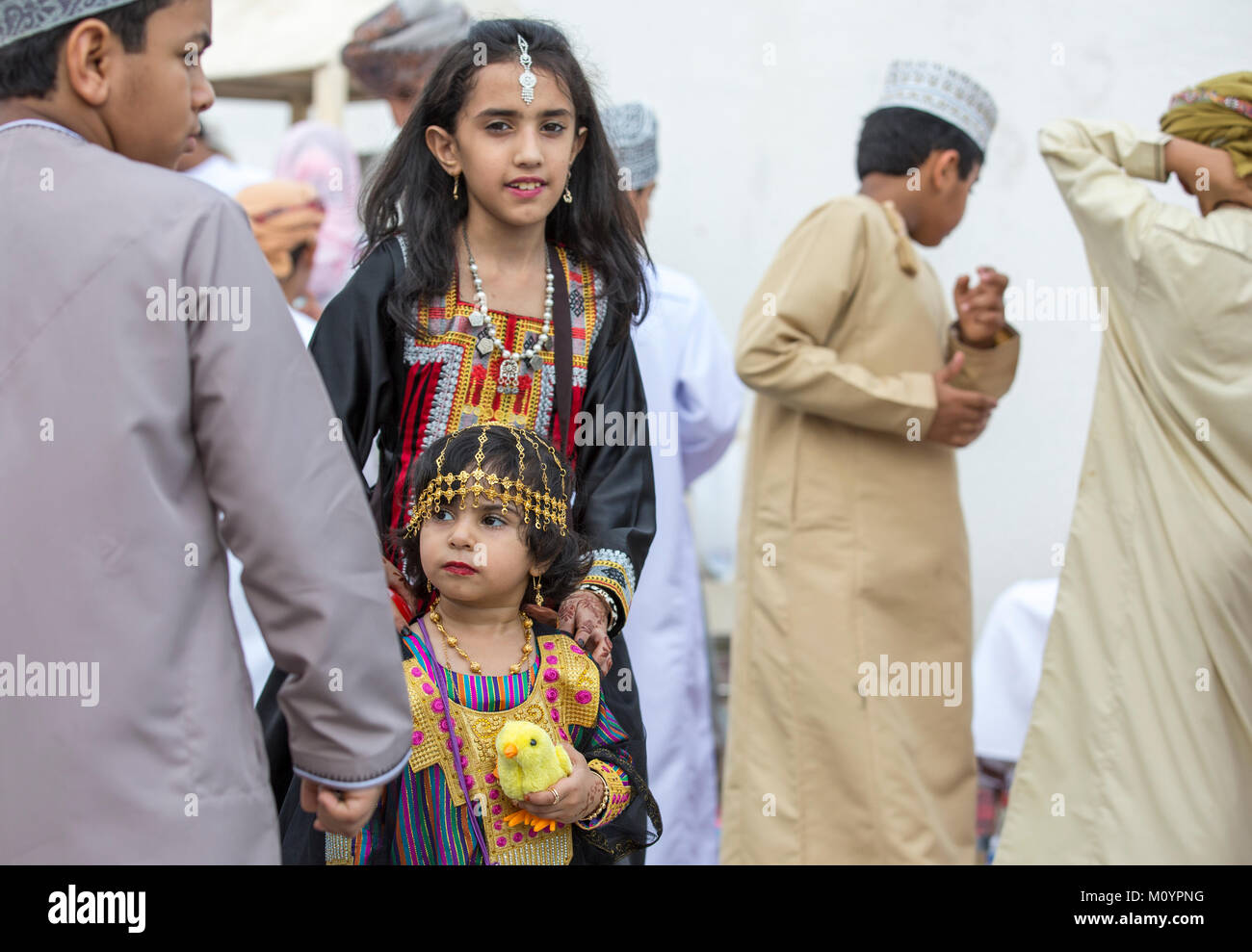 Nizwa, Oman - 26. Juni 2017: kleines Mädchen in traditionellen Outfit, mit ihrer Mutter zu einem Spielzeug Markt an einem Tag des Eid al Fitr Stockfoto