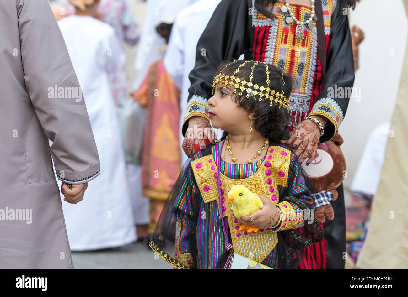 Nizwa, Oman - 26. Juni 2017: kleines Mädchen in traditionellen Outfit, mit ihrer Mutter zu einem Spielzeug Markt an einem Tag des Eid al Fitr Stockfoto