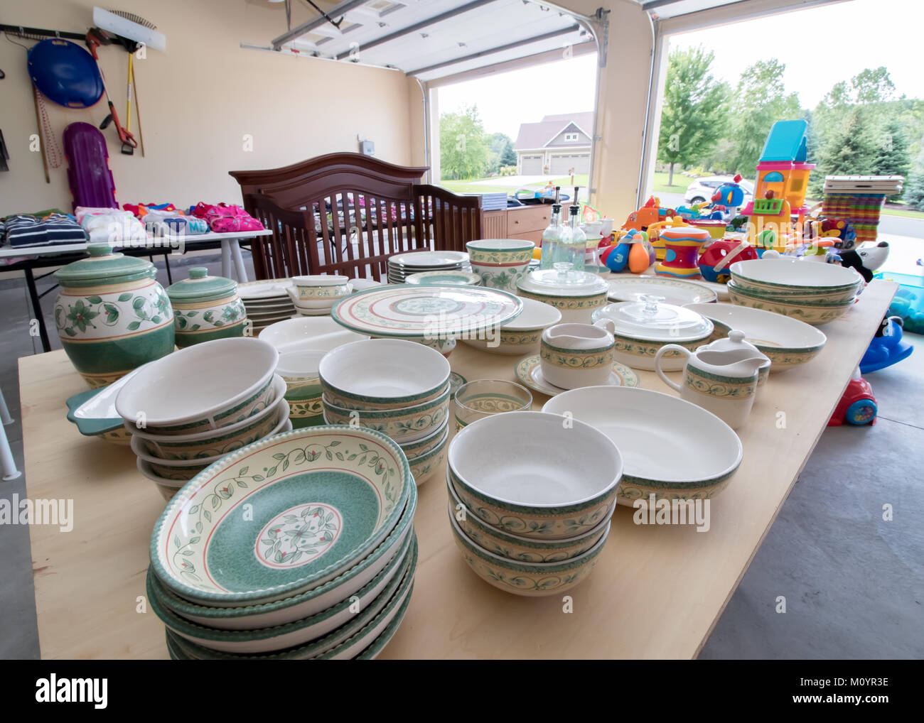 Tabellen voller Geschirr, Spielzeug und Kinderkleidung zum Verkauf an einer  typischen amerikanischen Garage Verkauf Stockfotografie - Alamy
