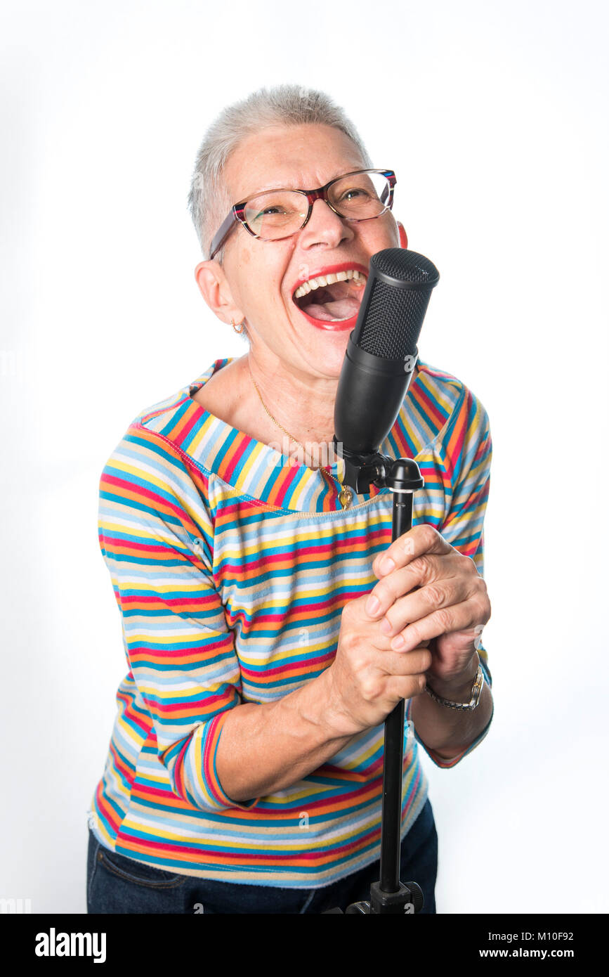 Senior alte Frau singen auf ein professionelles Mikrofon Stockfoto