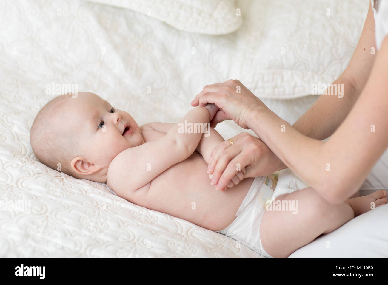 Baby-Massage. Mutter macht Gymnastik Kind Stockfoto