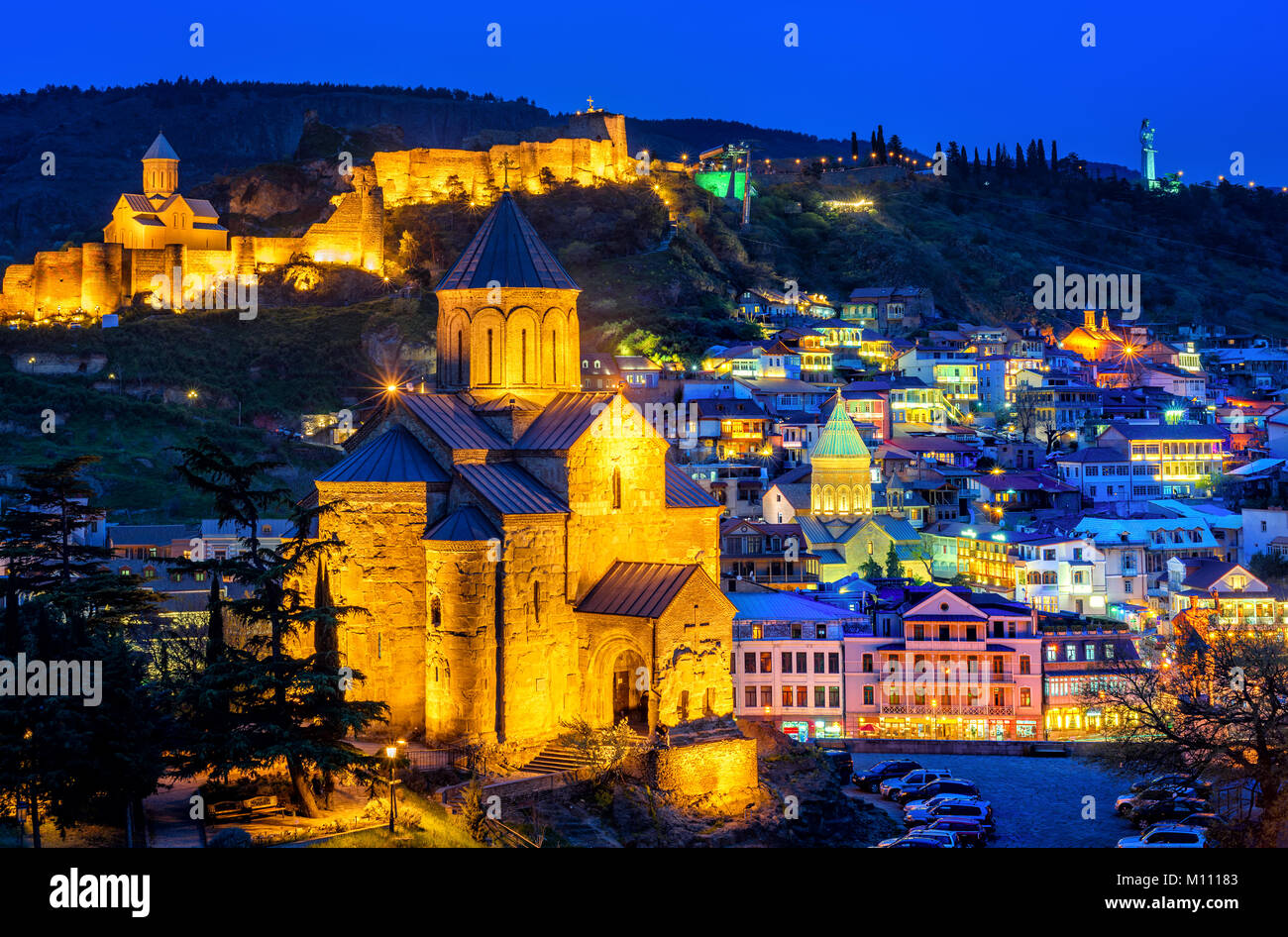 Historische Altstadt von Tiflis, Georgien, mit Metekhi Kathedrale, Festung Narikala, Armenische Kirche, beleuchtet bei Nacht Stockfoto