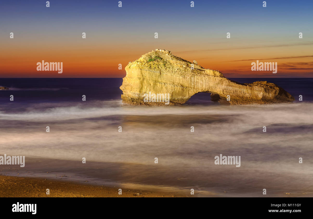 Die durchbohrte Gestein (Rocher Perce) am Miramar Beach in Biarritz, Frankreich, am Sonnenuntergang Stockfoto