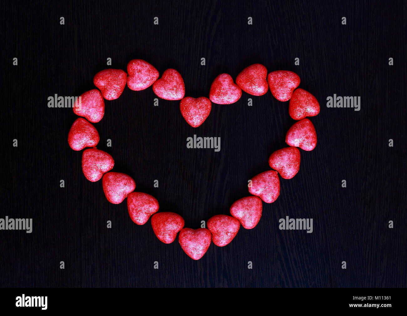 Rotes Herz aus kleinen Herzen auf einem dunklen Hintergrund Nahaufnahme. Stockfoto