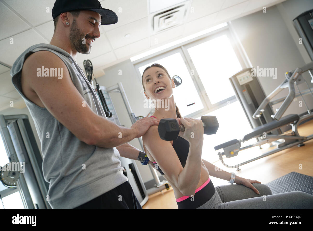 Fitness Mädchen arbeiten mit persönlichem Trainer im Fitnessraum Stockfoto