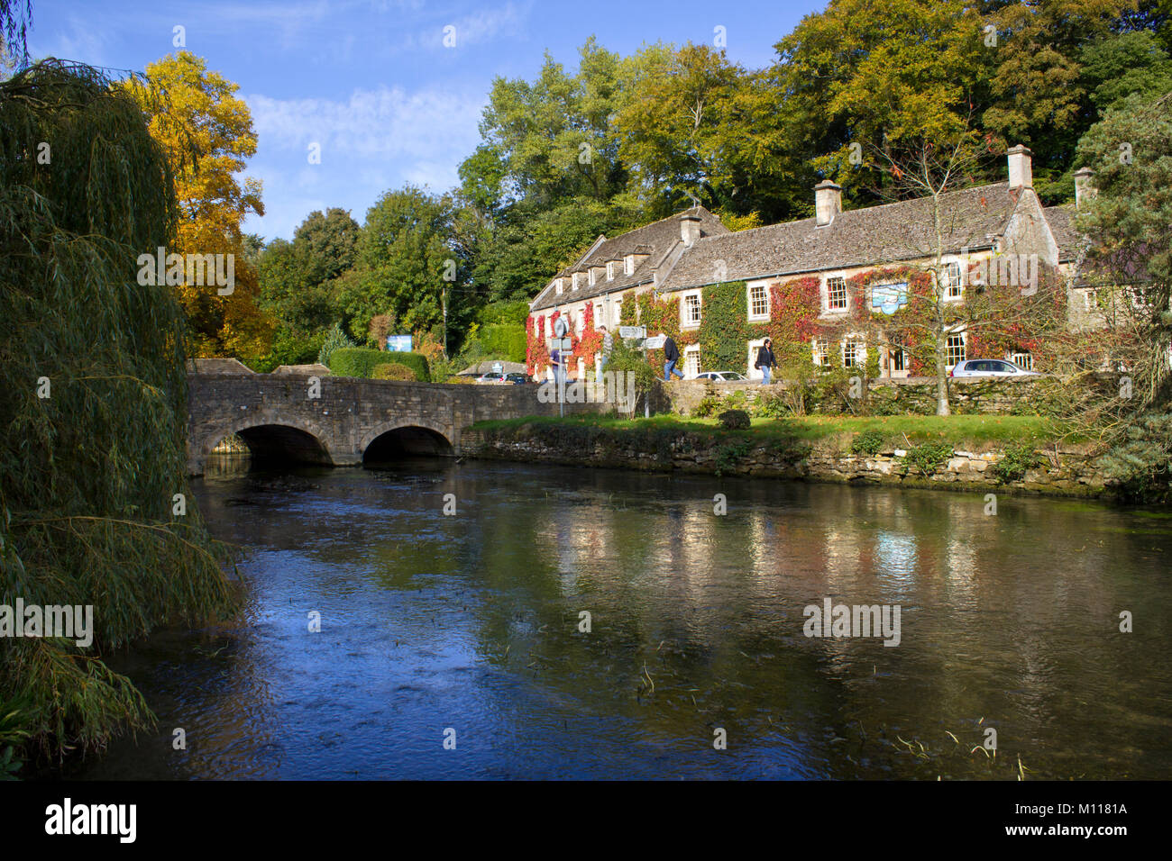 Bibury, Gloucestershire, Großbritannien - 7.. Oktober 2010: Klassische Frühherbstansicht der alten Brücke über den Fluss Coln in Bibury. Bibury wurde einst von William Morris (1834-96) als "das schönste Dorf in England" beschrieben. Stockfoto