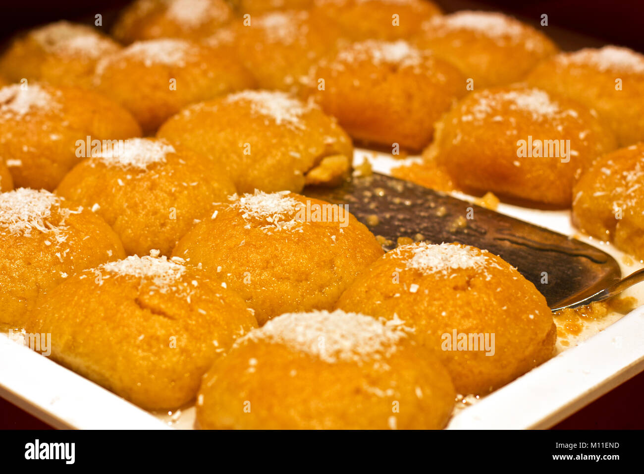 Türkische Spezialitäten mit Kokos Chips auf einem weißen Teller mit silber  Spachtel Stockfotografie - Alamy