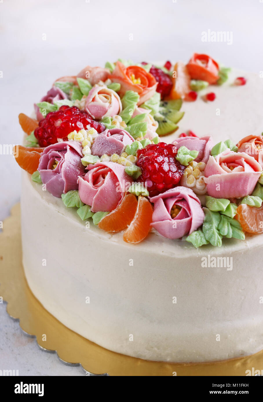 Festliche Kuchen mit cremefarbenen Blüten und Früchte auf einem hellen Hintergrund Stockfoto