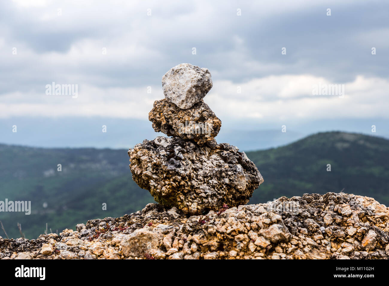 Schöne Steine im Gleichgewicht auf eine Betonwand überlagerte an der Seite der Straße. Calascio, Provinz L'Aquila, Abruzzen, Italien Stockfoto