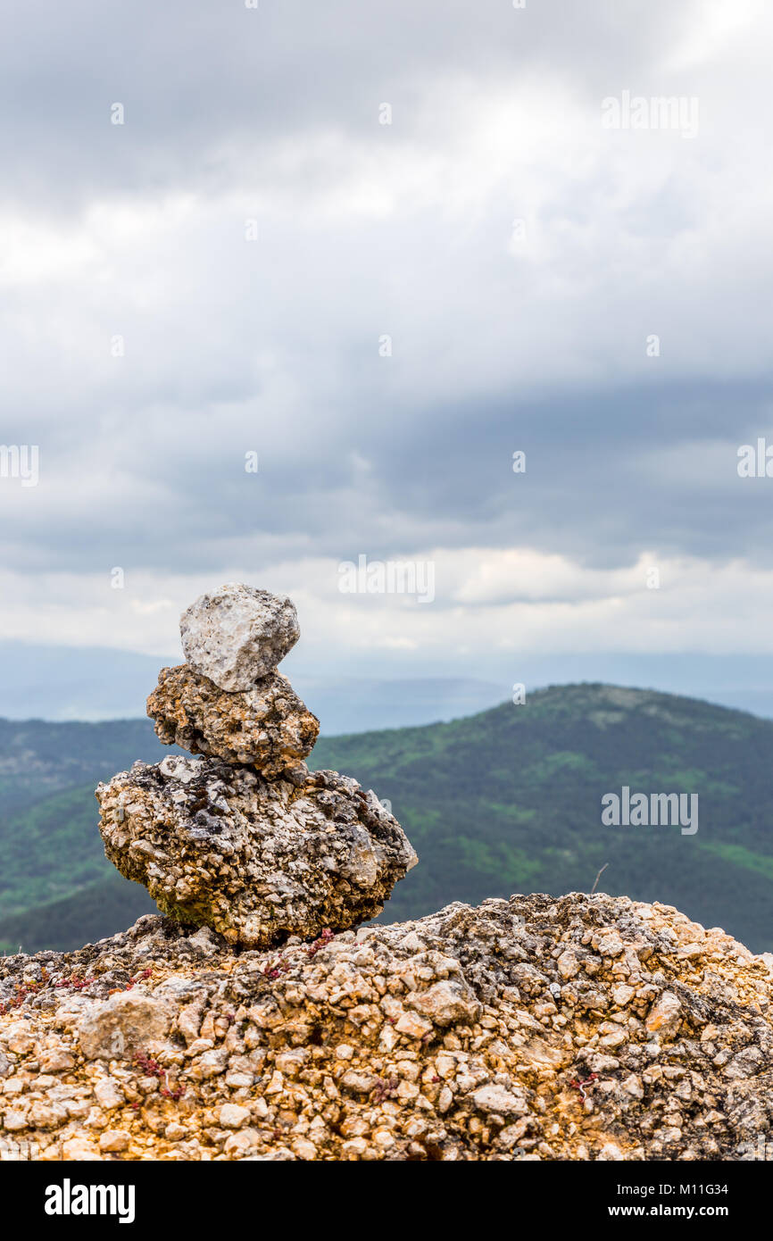 Schöne Steine im Gleichgewicht auf eine Betonwand überlagerte an der Seite der Straße. Calascio, Provinz L'Aquila, Abruzzen, Italien Stockfoto