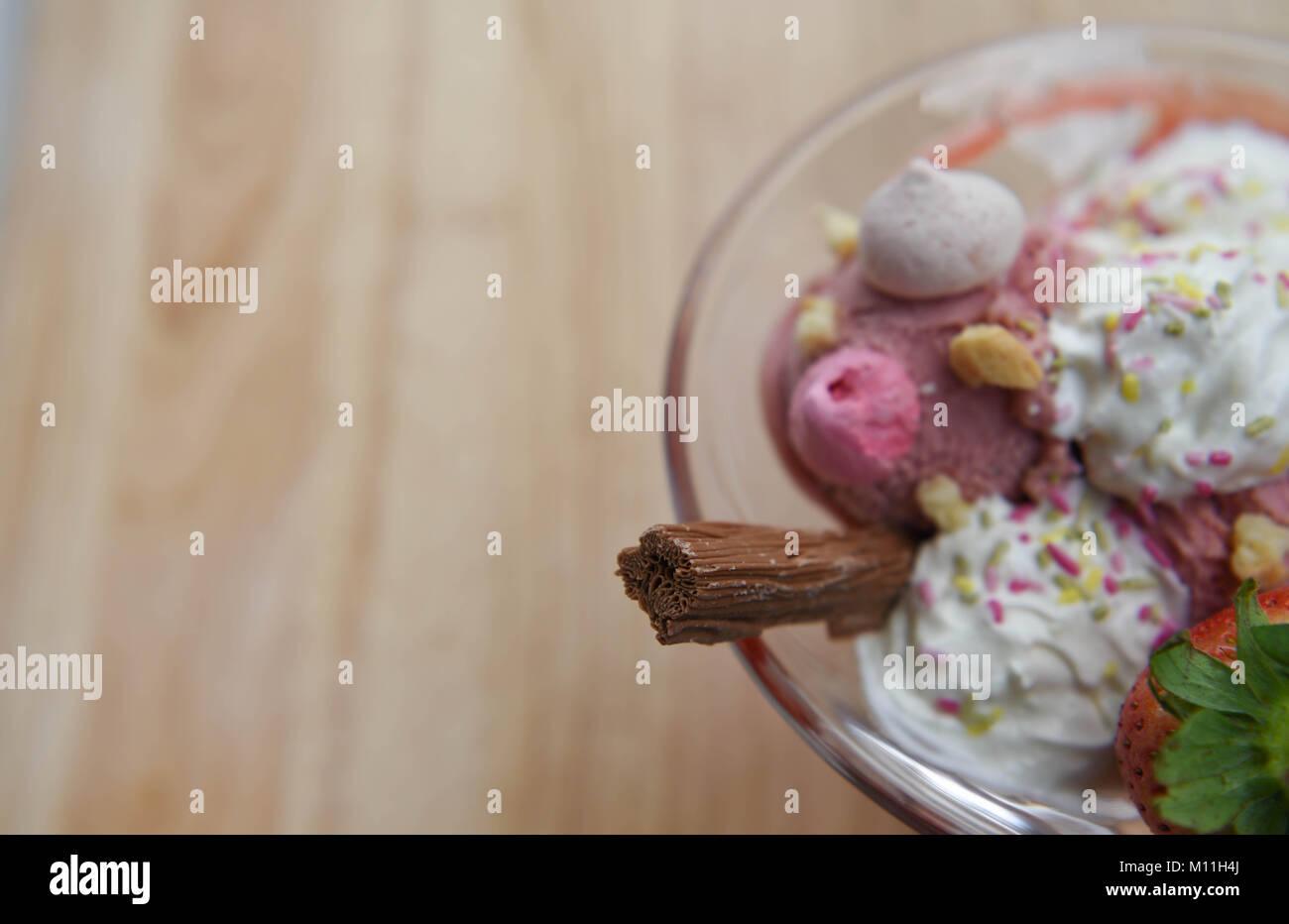 Über dem Kopf fotografie Ansicht einer köstlichen Sommer Erdbeeren Eisbecher in einem Glas Schale mit Obst baiser Sahne und Schokolade Stockfoto