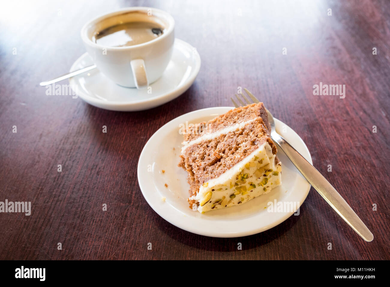 Schwarzen Kaffee und einige teilweise gegessen Kuchen auf einem Holztisch Stockfoto