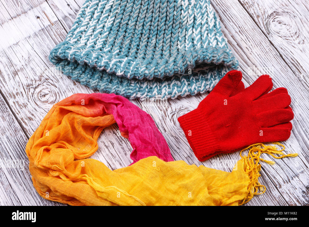 Zubehör für rote Handschuhe, bunten Schal und eine Mütze gestrickt. Stockfoto