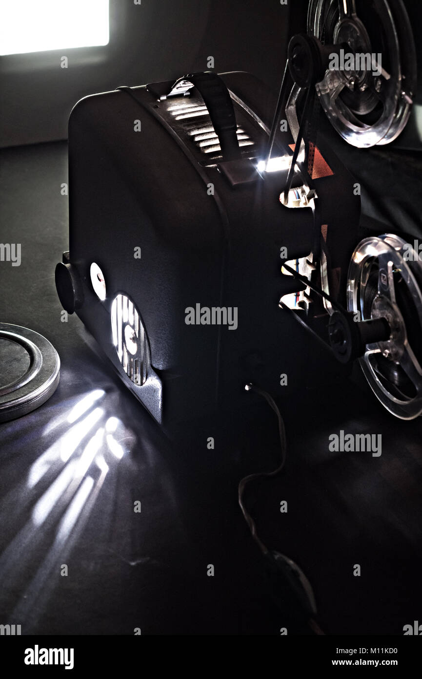 Alter Film Projektor und einem leuchtenden Bildschirm in der Dunkelheit Stockfoto