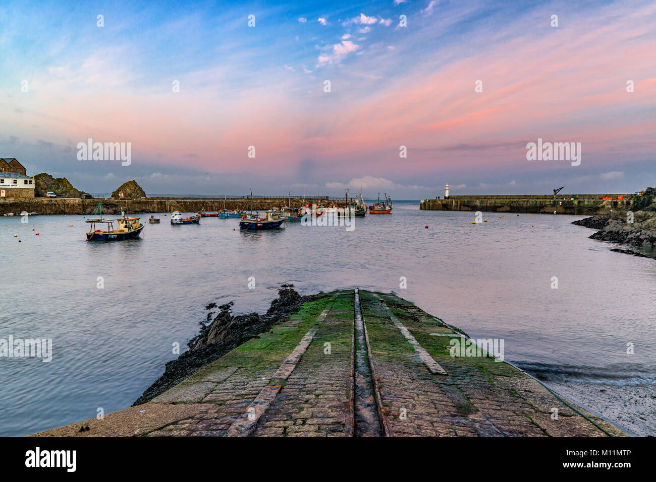 Aus Blick auf das Meer über die äußeren Hafen von Mevagissey mit der alten Rettungsboot helling als Vordergrund Interesse und führenden Leitung. Stockfoto