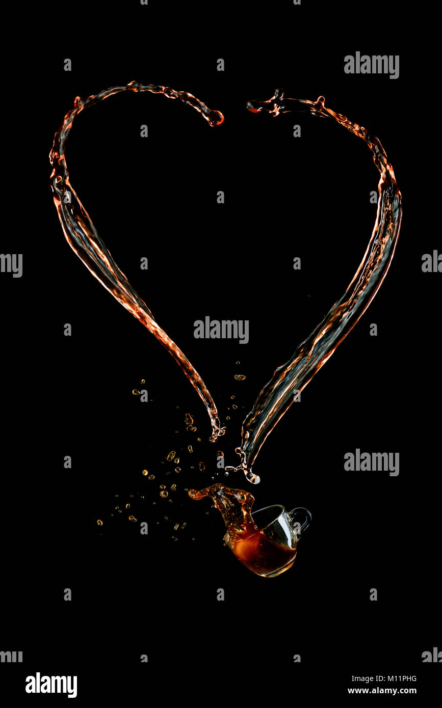 Herzförmige Kaffee Splash mit einem Glas Espresso Tasse auf einem schwarzen Hintergrund. Liquid high-speed Fotografie. Essen in Bewegung. Stockfoto