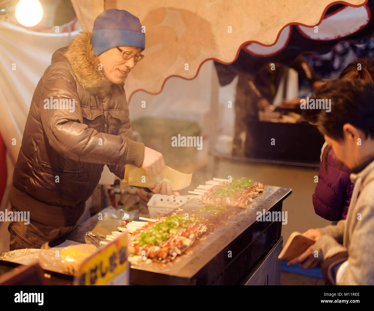 Japanische Street Food vendor verkaufen Hashimaki, Okonomiyaki rollte auf Stäbchen, an einem Street Food Markt in Kyoto, Japan Stockfoto