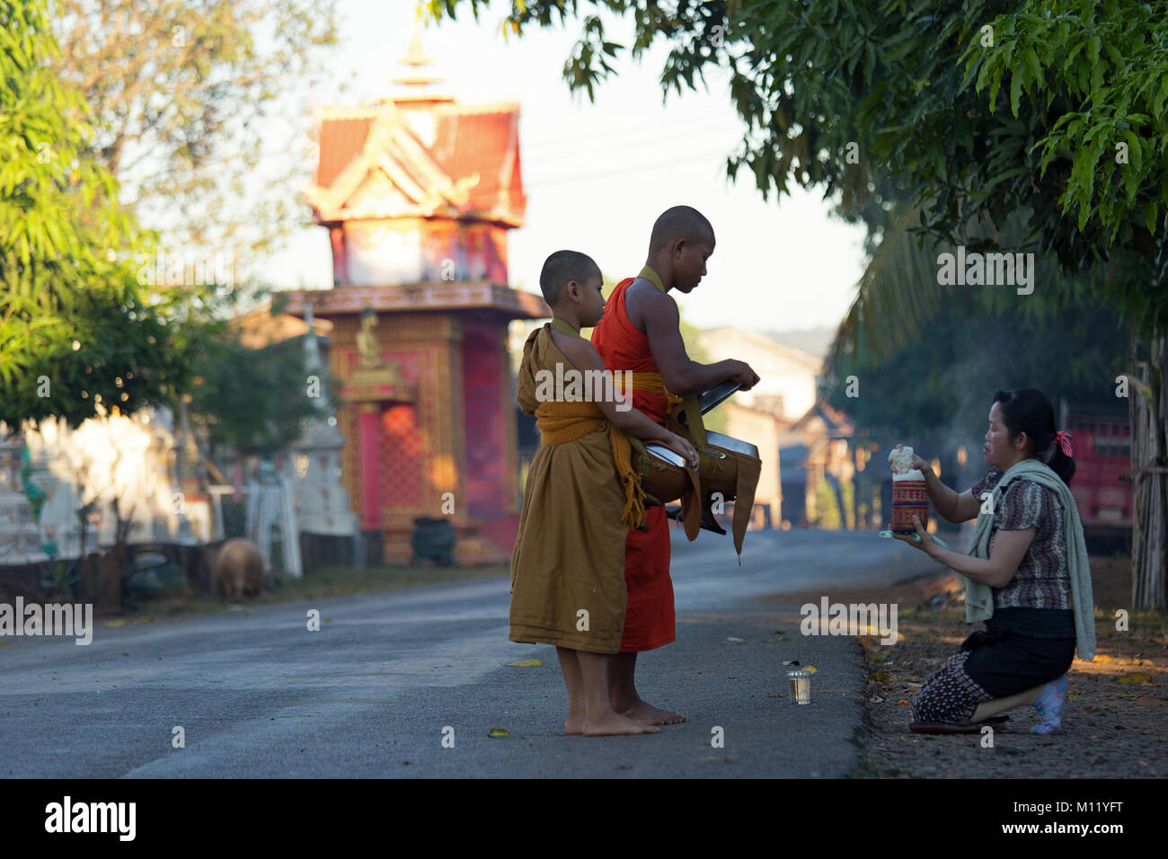 Junge Mönche in Säcke für ihre Nahrung in den frühen Morgen in Tad Lo Dorf - südliche Laos Indochina Stockfoto