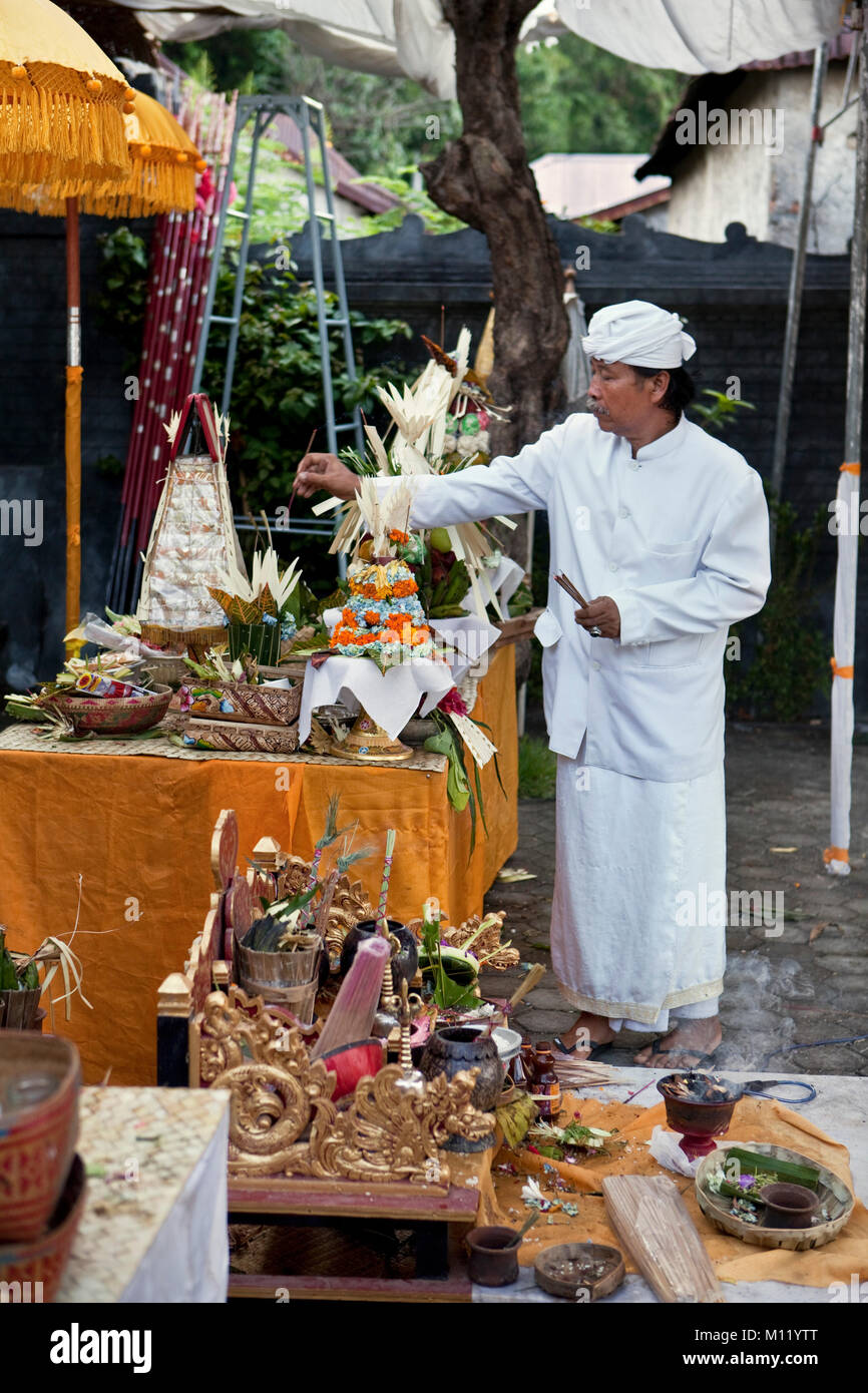 Indonesien, Insel Bali, Tejakula Dorf, Pura Maksan Tempel. Hindu-priester, Räucherstäbchen auf Angebote. Stockfoto