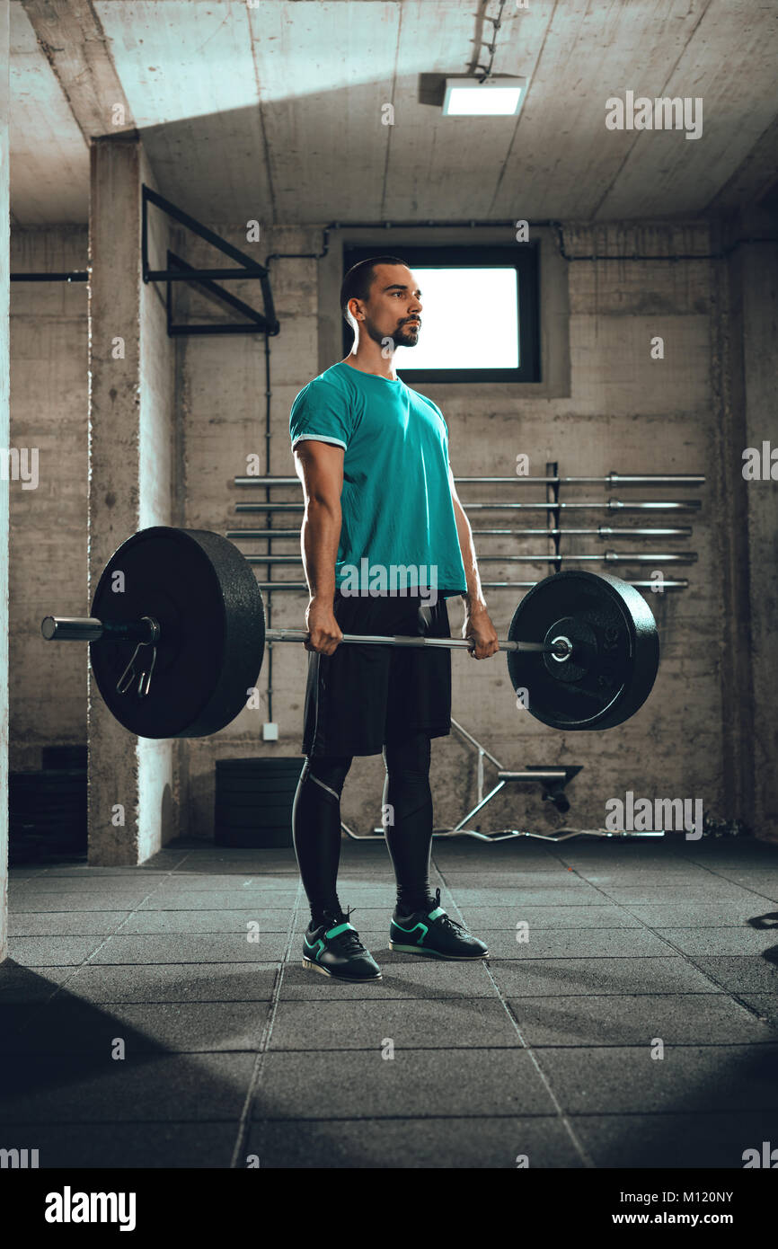 Junge muskulöse Mann bereit, trainieren Sie im Fitnessraum zu deadlift. Stockfoto
