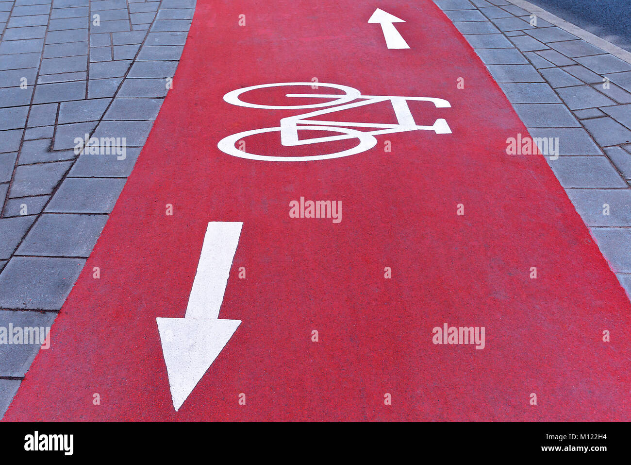 Red Radweg mit weißen Abzeichen, Fahrrad- und Richtungspfeile, Bayern, Deutschland Stockfoto