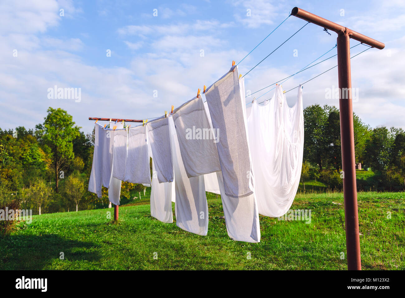 Frisches sauberes weißes Blatt trocknen auf der Wäscheleine im Freien Stockfoto