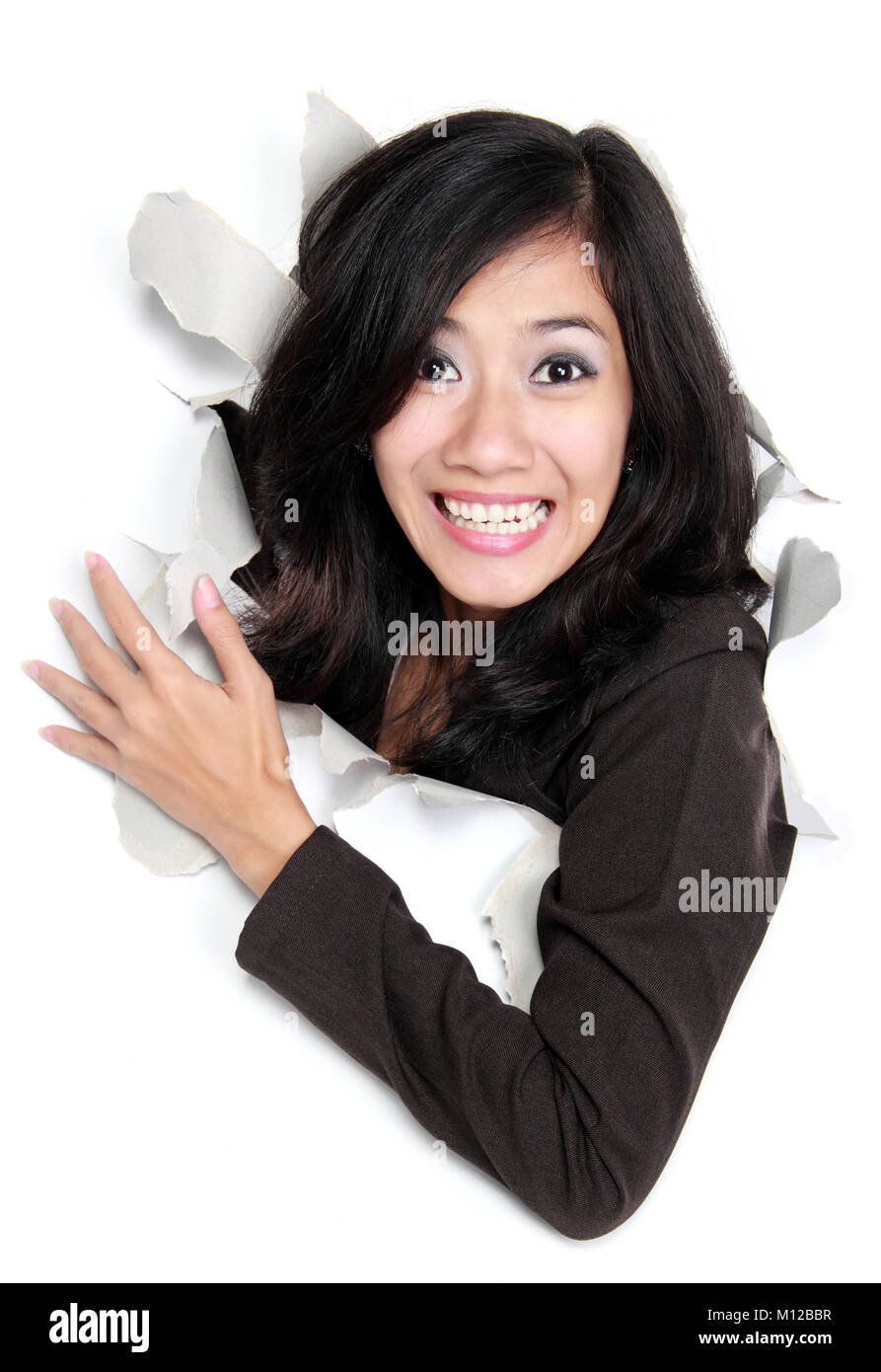 Glückliche junge Frau auf der Suche durch ein Loch. Auf weissem Hintergrund Stockfoto