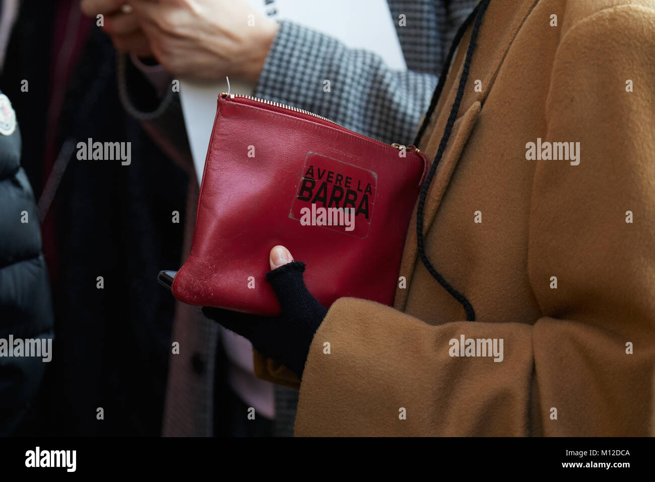 Mailand - Januar 14: Mann mit rotem Leder Tasche und beige Mantel vor MSGM fashion show, Mailand Fashion Week street style am 14. Januar 2018 in Mailand. Stockfoto