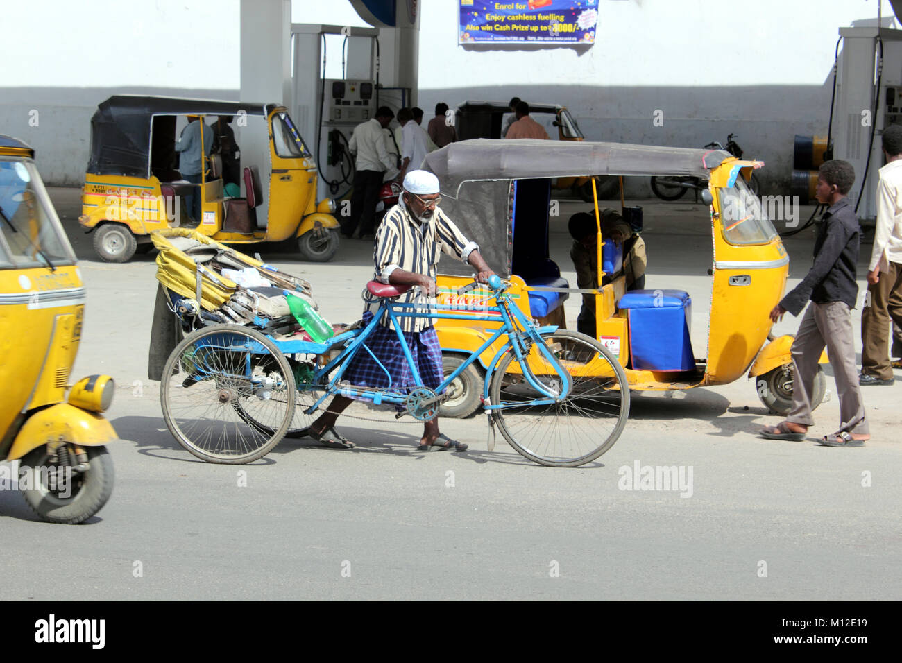 Mann drücken Zyklus Rikscha entlang der Straße in Hyderabad, Indien Stockfoto