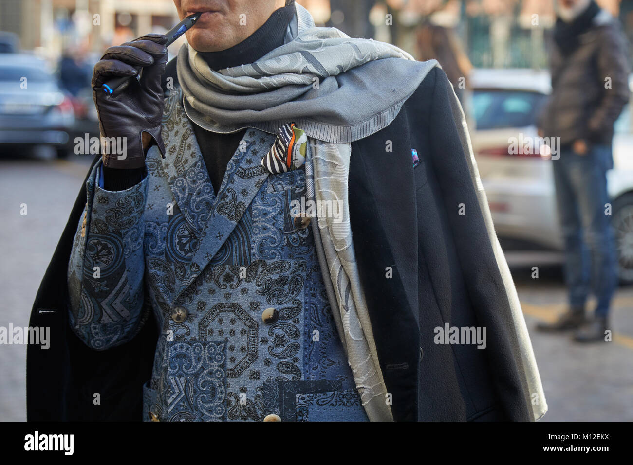 Mailand - Januar 14: Mann mit blauen Anzug, grau Schal und elektronische Zigarette vor dem Daks-fashion show, Mailand Fashion Week street style Jan Stockfoto