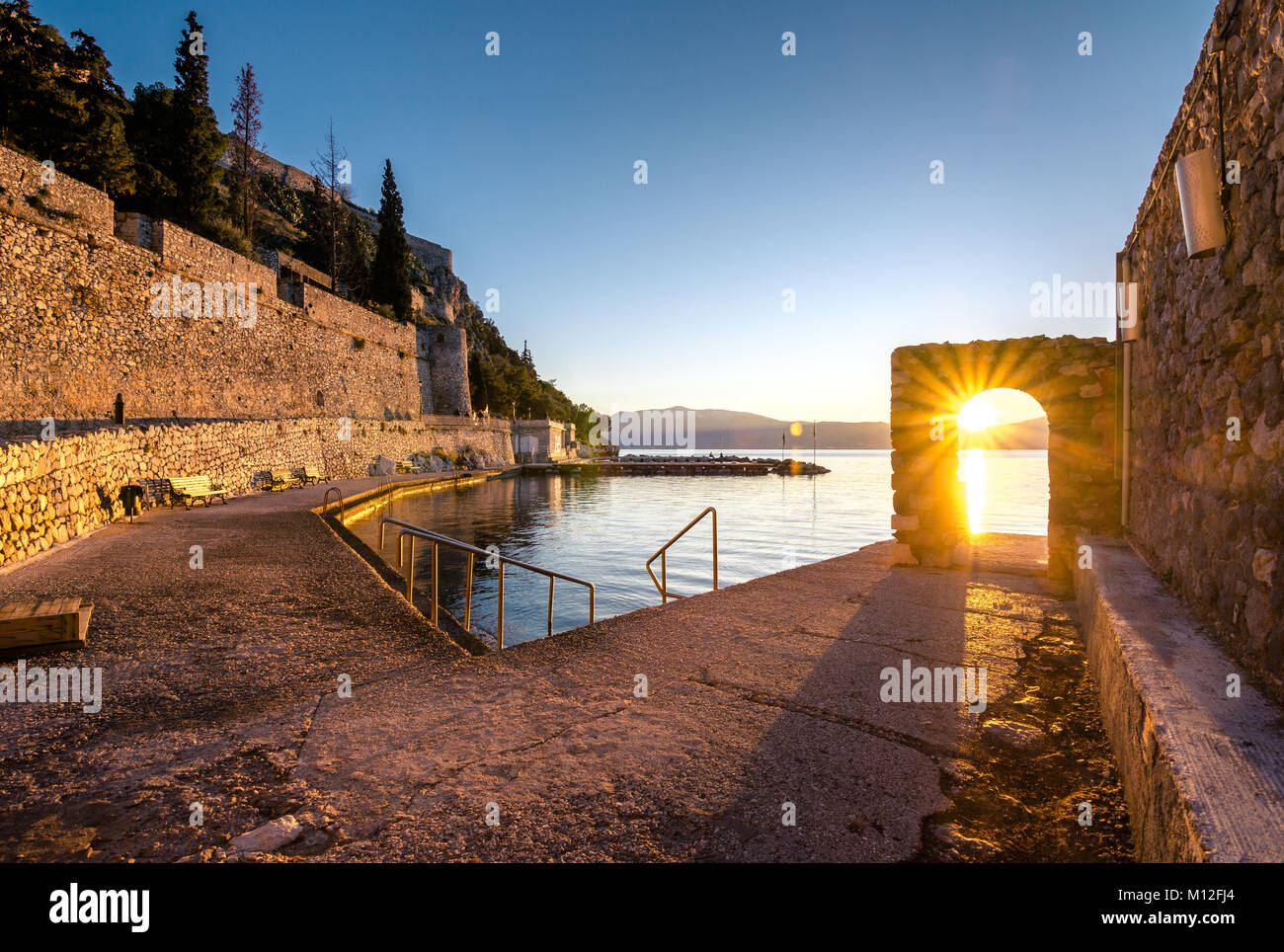 Schönen Hafen von Nafplio Stadt in Griechenland mit kleinen Booten, Palmen und Burg Bourtzi auf dem Wasser. Stockfoto