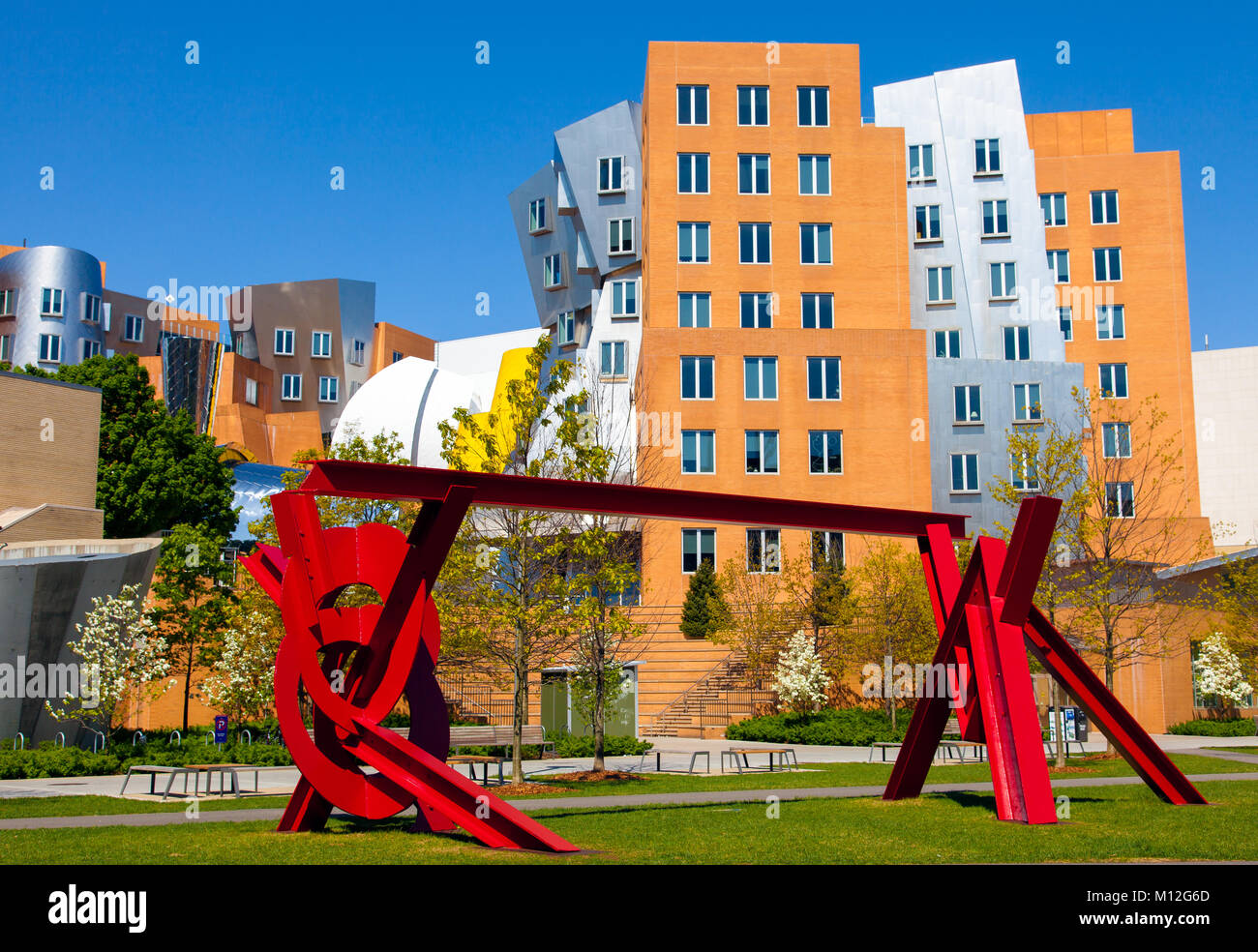 MIT Campus rote Metall Skulptur des Künstlers Mark Di Suvero im Vordergrund und die Ikonischen Stata Center von dem Architekten Frank Gehry im Hintergrund Stockfoto