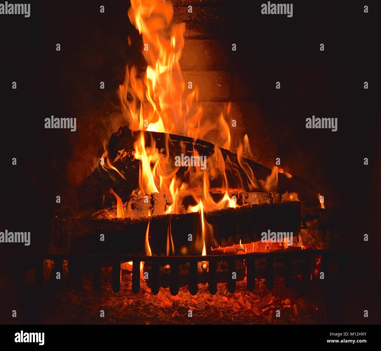 Kamin mit einem brennenden Feuer und Holz Stockfotografie Alamy