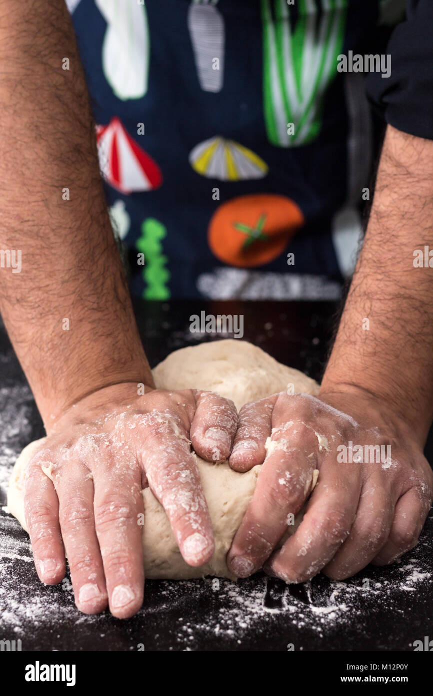 Männliche Hände Teig kneten, backen Vorbereitung Nahaufnahme. Stockfoto