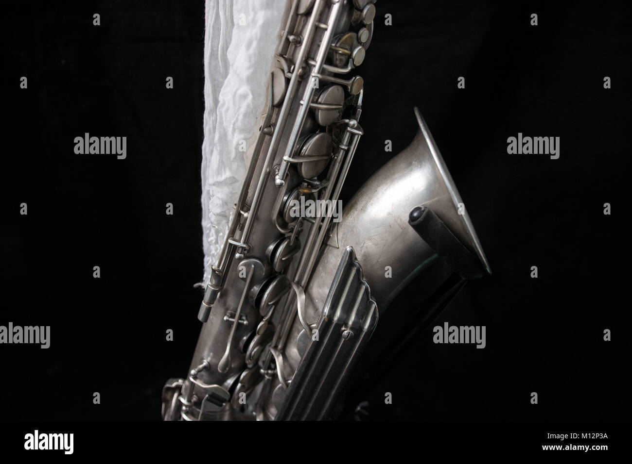 Nahaufnahme von einem Saxophon dekoriert mit einem weißen Tuch in Schwarz isoliert Stockfoto