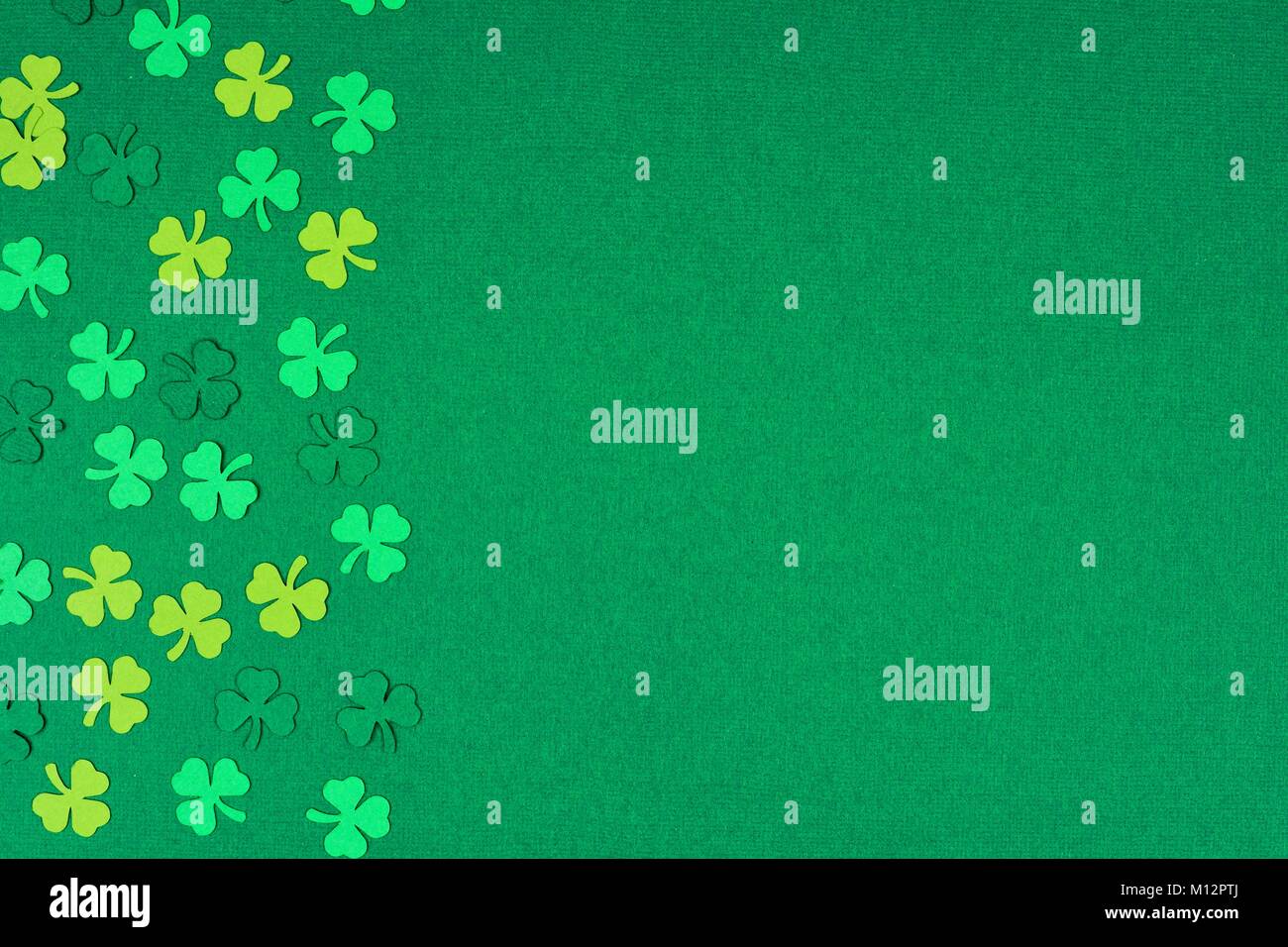 St Patricks Day Seite Papier Shamrocks auf eine grüne strukturierten Hintergrund Stockfoto