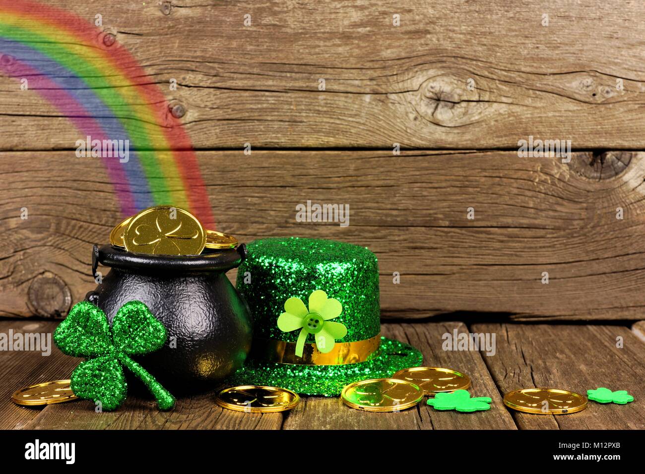 St Patricks Day Pot of Gold mit Regenbogen, Shamrocks und Hut gegen rustikalen, mit Holz Stockfoto