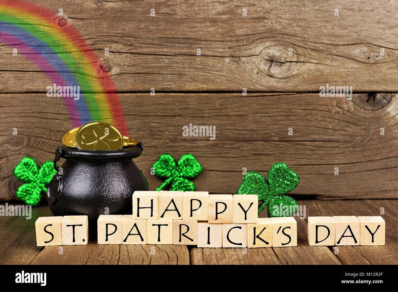 Happy St Patricks Day Holzblöcke mit Pot of Gold, Regenbogen und Shamrocks gegen rustikalen, mit Holz Stockfoto